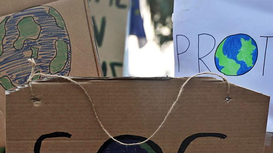 Una niña sostiene una pancarta de lucha contra el cambio climático.