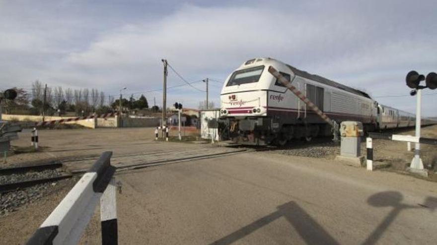 Paso del tren Talgo a Galicia, a media tarde de ayer, por el paso a nivel que se corta a partir de mañana.