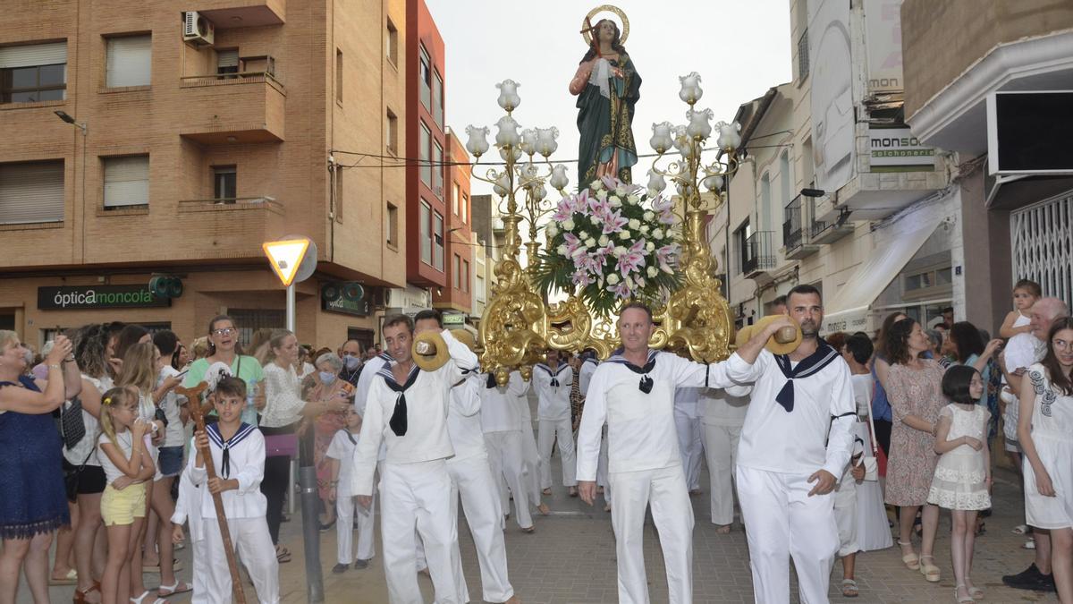 Los marineros cargan con la imagen de Santa María Magdalena durante un instante de la procesión.