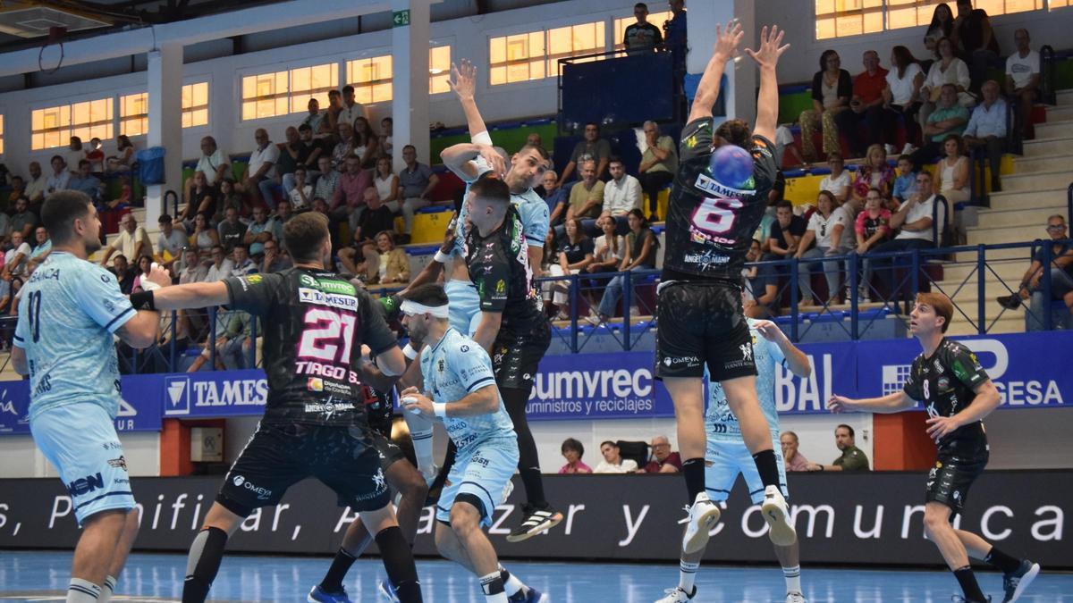 El jugador rumano del Frigoríficos Rares Fodorean lanza ayer a portería defendido por varios jugadores del Puente Genil.