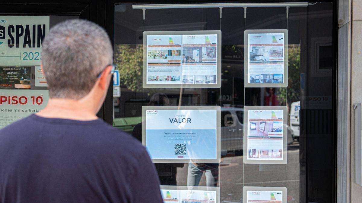 Una persona observa el escaparate de una inmobiliaria en Vigo.
