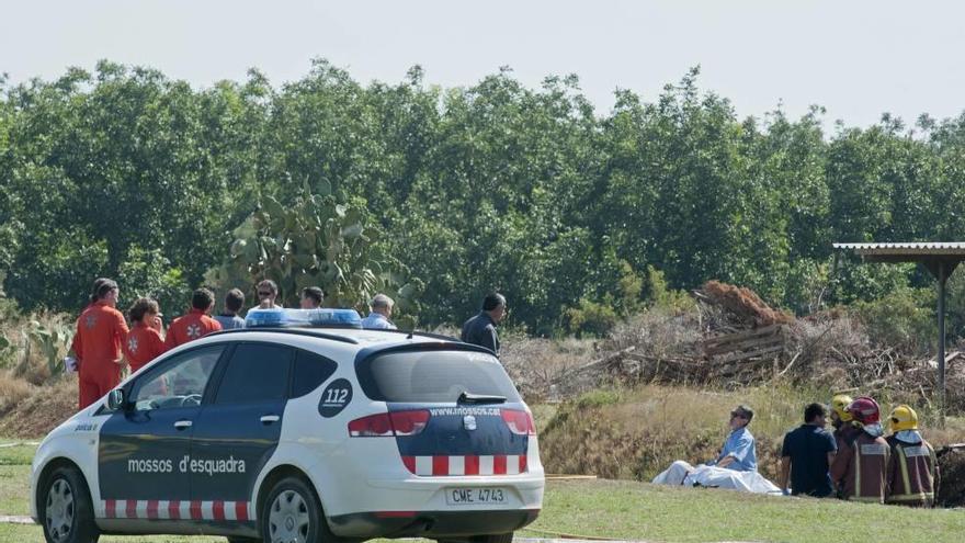 Un vehículo de los Mossos d´Esquadra en el campo de Viladamat donde se produjo el accidente mortal de los dos pilotos mallorquines.