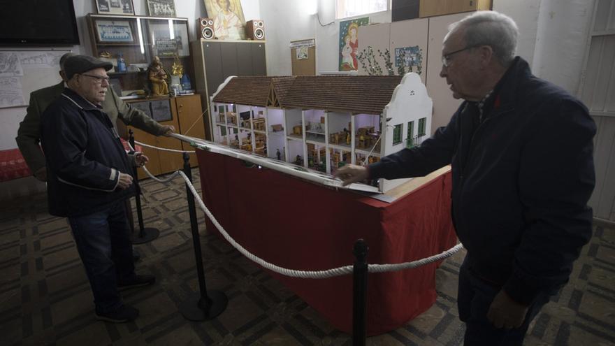 Antiguos alumnos del Colegio de Aprendices, de la siderurgia del Port de Sagunt, muestran su maqueta cargada de recuerdos, que se puede visitar en la iglesia de Begoña.