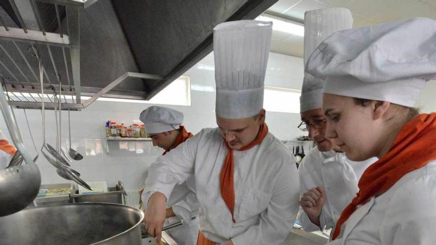 Alumnos de la escuela de Moreda preparan un plato.