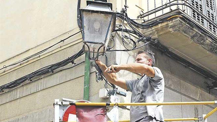 Ein Arbeiter repariert eine Straßenlaterne in Sóller.