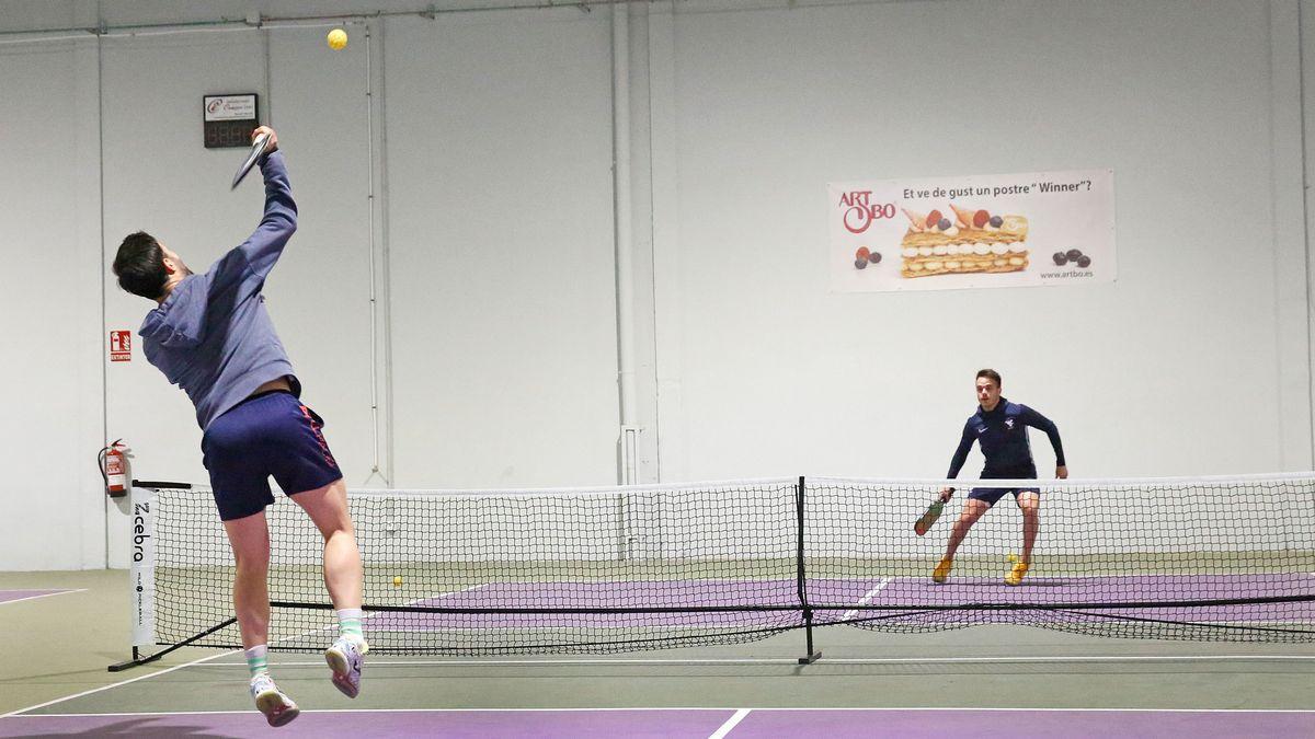 Dos jugadores pelotean en una pista de pickleball en Sabadell.