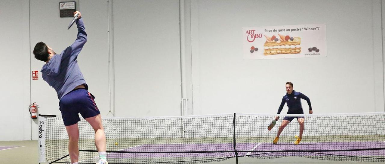 Dos jugadores pelotean en una pista de pickleball en Sabadell.