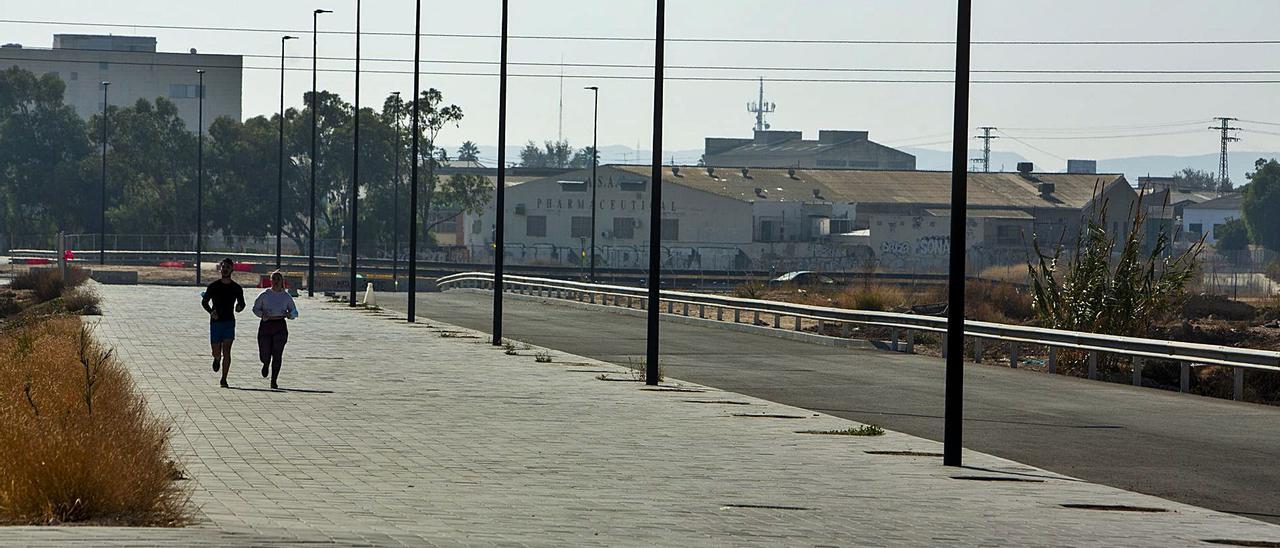 Dos jóvenes corren por la acera del tramo Vía Parque en el PAU 1 que sigue cerrado pese a estar la obra terminada hace meses.