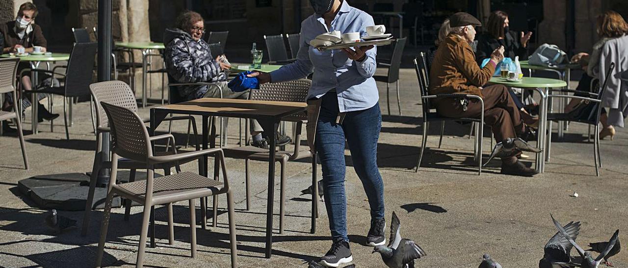 Una camarera atiende las terrazas de un local de la plaza Mayor de Ourense. |   // BRAIS LORENZO