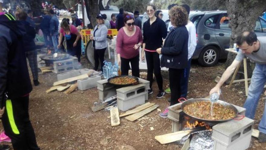 Varios grupos de concursantes cocinan sus paellas.