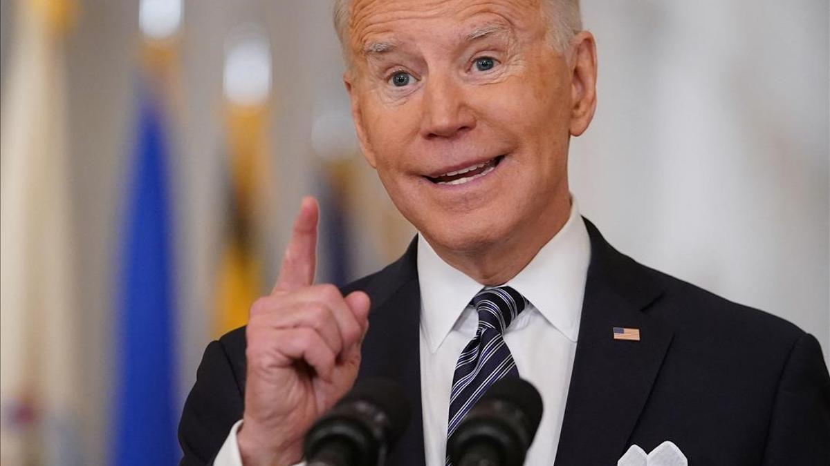 TOPSHOT - US President Joe Biden gestures as he speaks on the anniversary of the start of the Covid-19 pandemic  in the East Room of the White House in Washington  DC on March 11  2021  (Photo by MANDEL NGAN   AFP)