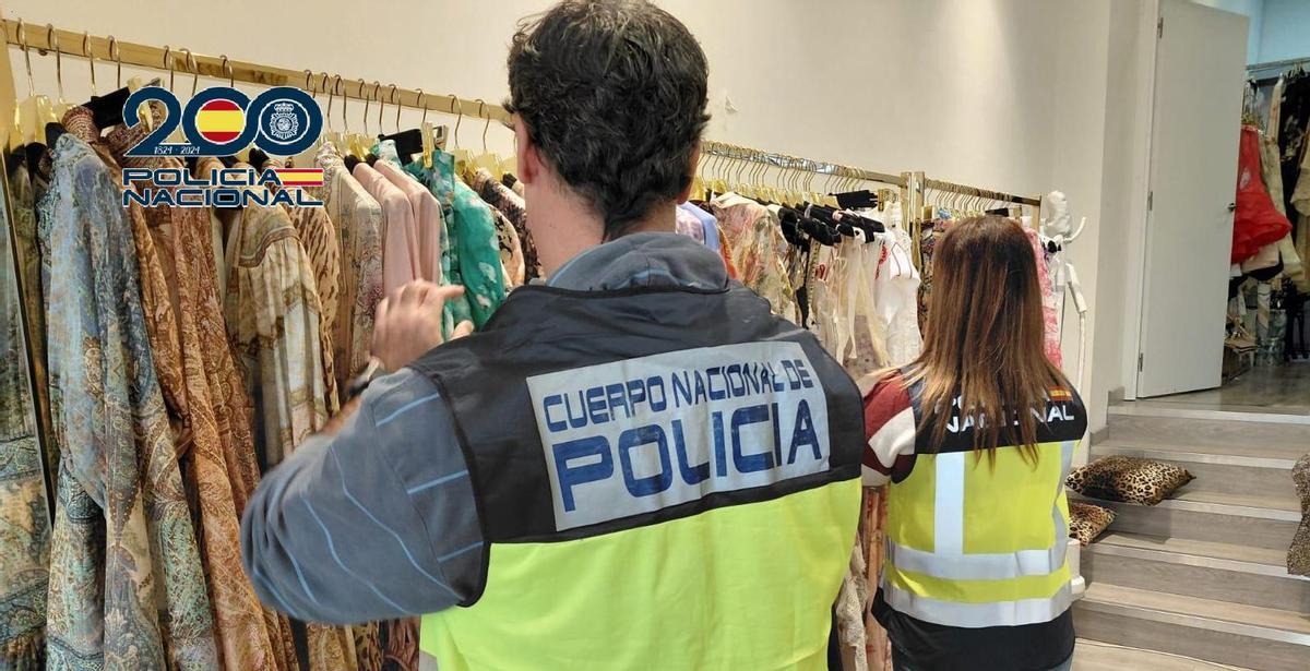 Dos agentes inspeccionan una de las tiendas implicadas.