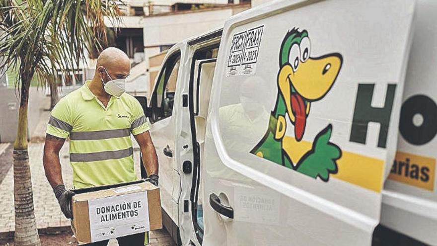 Un trabajador de HiperDino prepara el transporte de alimentos donados.