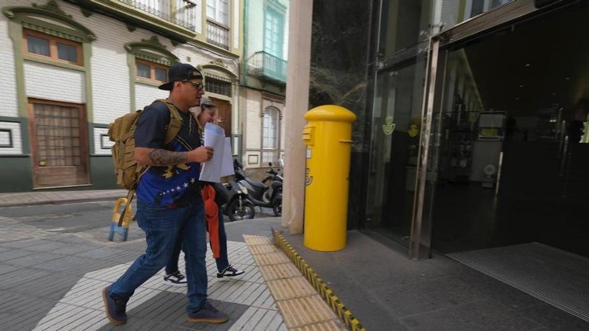 Venezolanos en una oficina de Correos para tramitar su regularización.