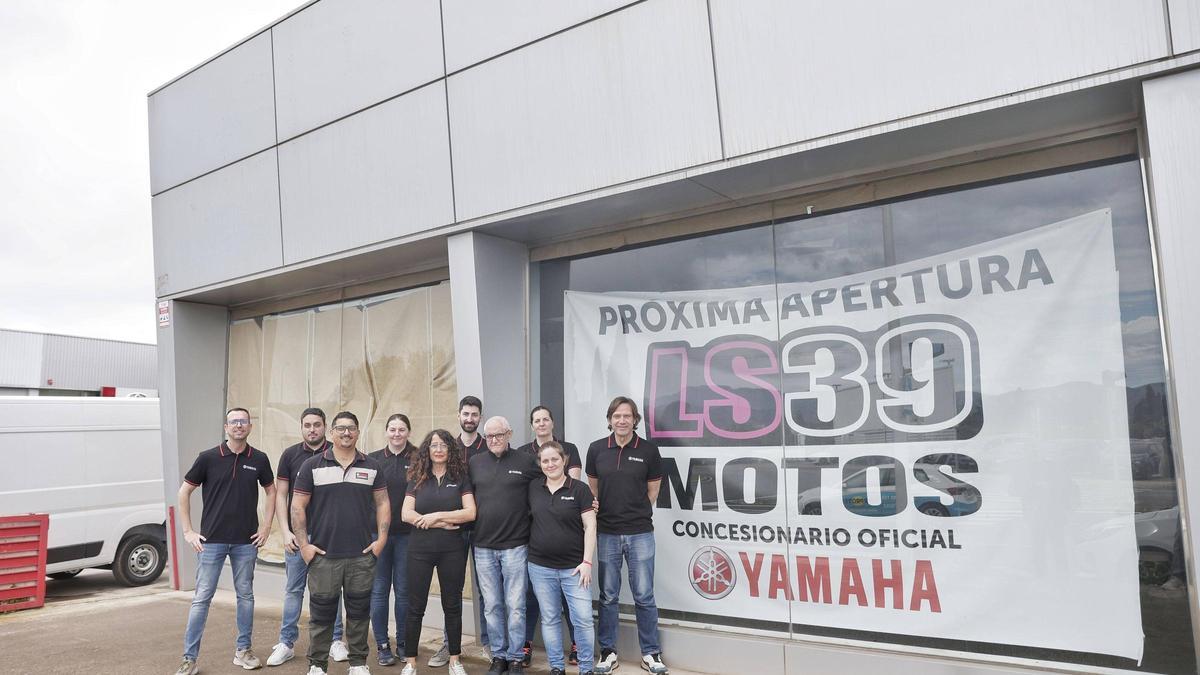 Lluís Salom y María Horrach posan con los trabajadores en el exterior del concesionario Yamaha LS39 Motos.