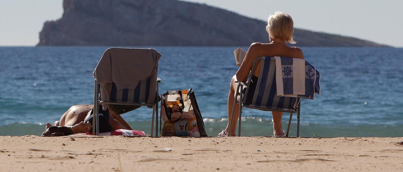Turistas disfrutan del sol y de la playa de Benidorm.