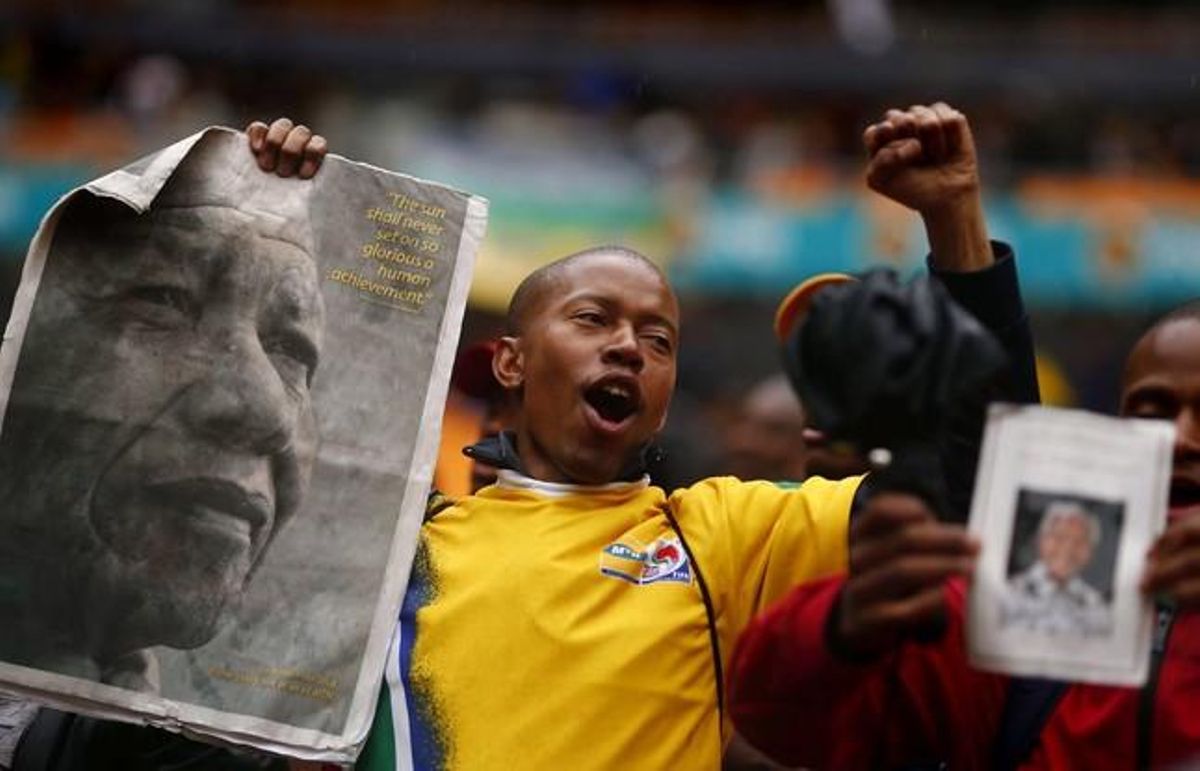 Els assistents a l’estadi FNB entonen càntics per Mandela, a l’arribar a la cerimònia.