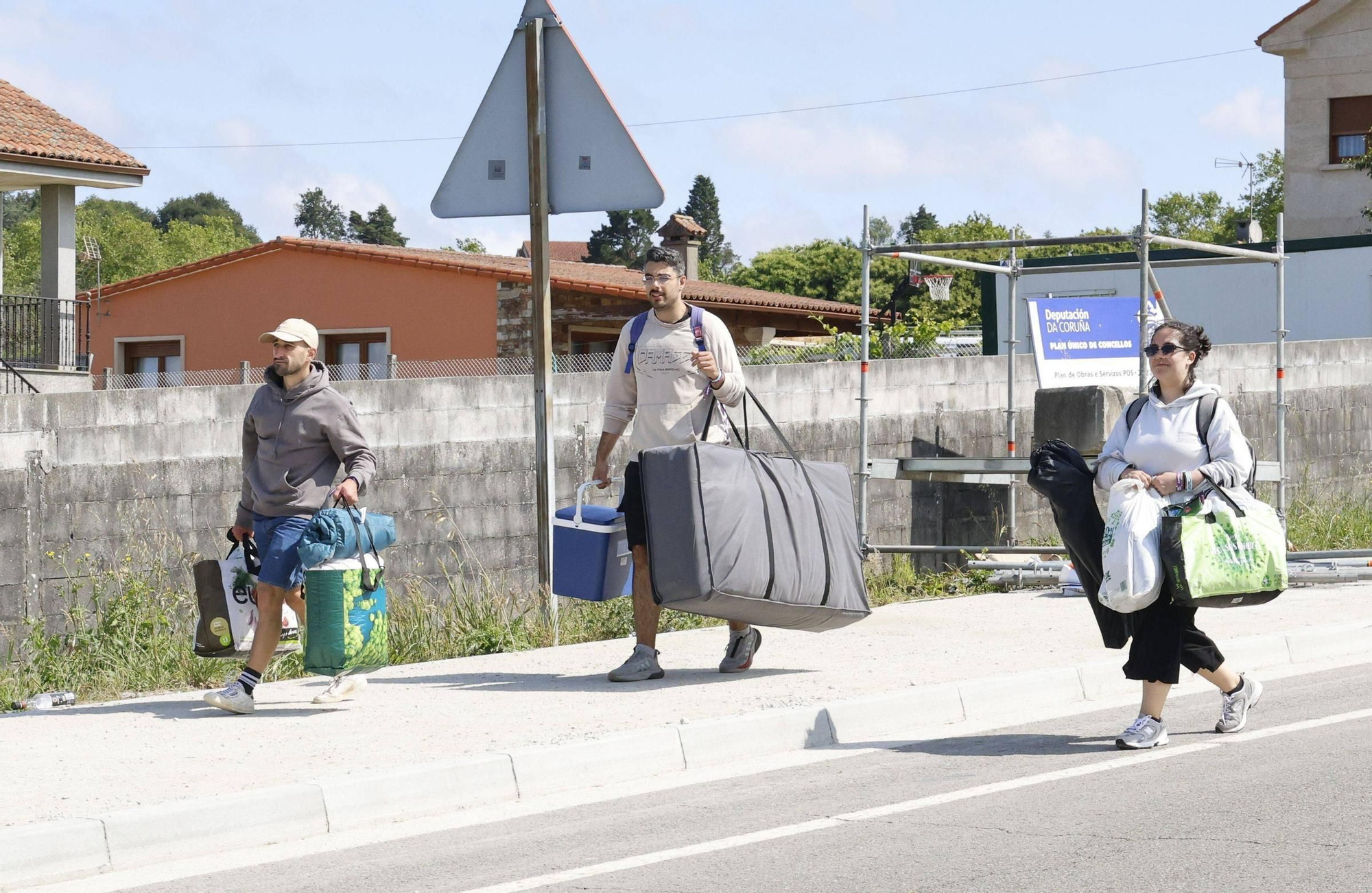 Vuelta a la realidad, paso a paso y mochila a cuestas: los campistas abandonan el Monte do Gozo