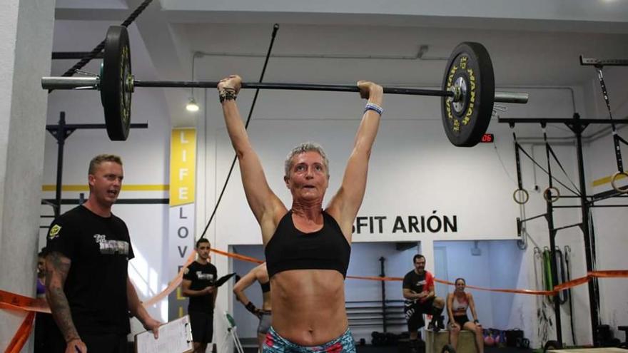 A la izquierda: Fernando Sánchez, del Crossfit Orotava, levanta una barra en un wod outdoor. A la derecha: Cristina Concepción (Crossfit Isla Bonita) bloquea la carga.