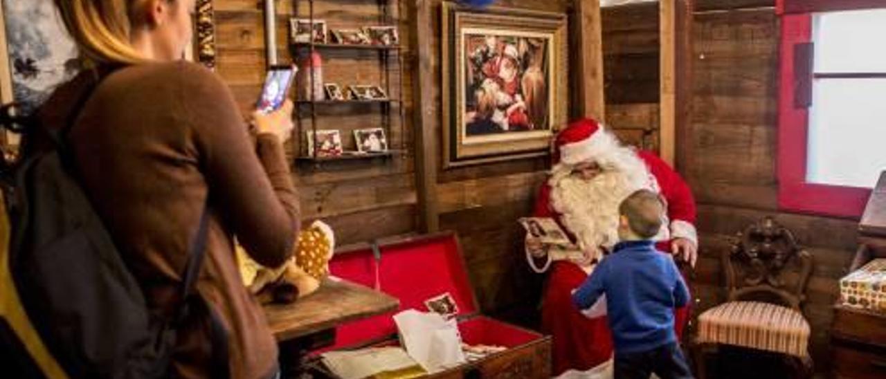 Una mujer fotografía a un niño y a Papá Noel con el móvil, días atrás, tras levantarse su prohibición.