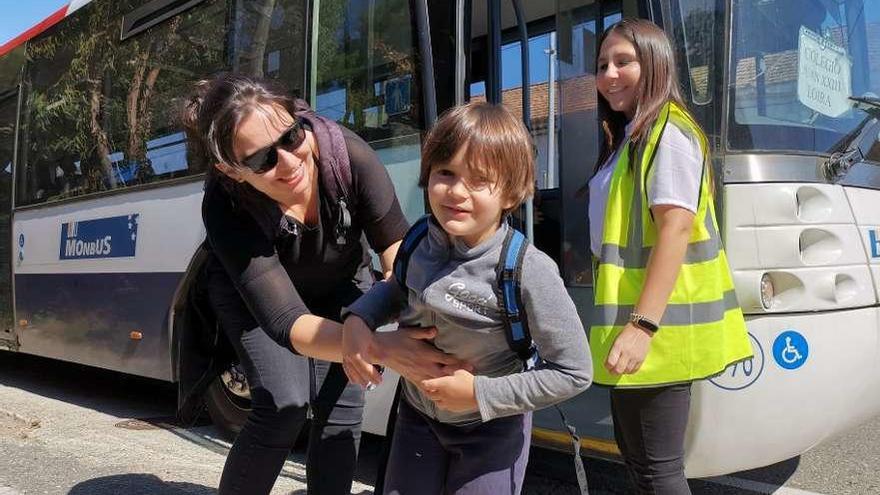 Isabel Castro junto a su hijo Uxío junto al autobús que cada día le llevará al colegio. // Santos Álvarez