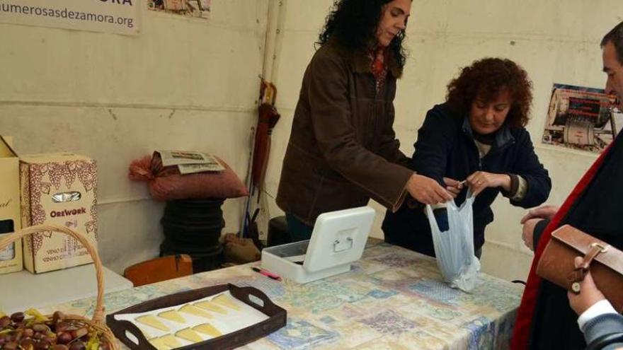 Dos de las voluntarias venden cucuruchos de castañas asadas en un expositor ubicado en la plaza de Santa María.