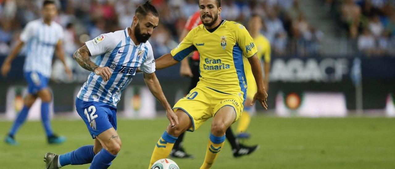 Kirian, a la derecha, persigue y presiona la salida de balón del lateral derecho del Málaga, Cifu.