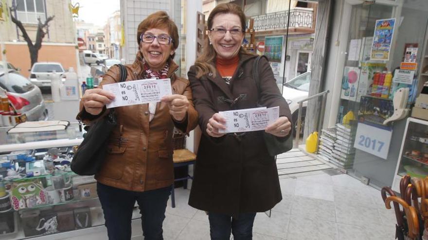 Dos mujeres muestran sus participaciones de lotería.