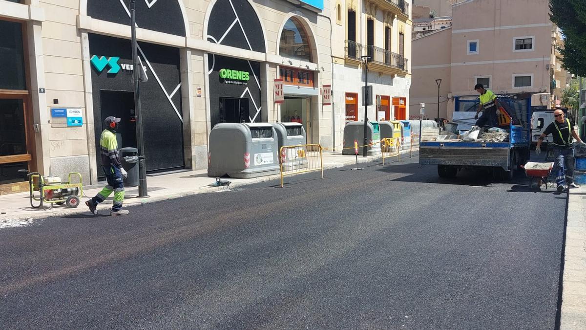 Trabajos de asfaltado en la plaza Alexandre Jaume durante la alerta naranja del pasado día 29.