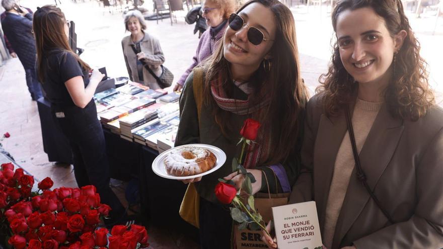 Lucía Campoamor y Covadonga Fernández muestran una rosca, rosas y libros, ayer, en una librería en Oviedo. | LUISMA MURIAS