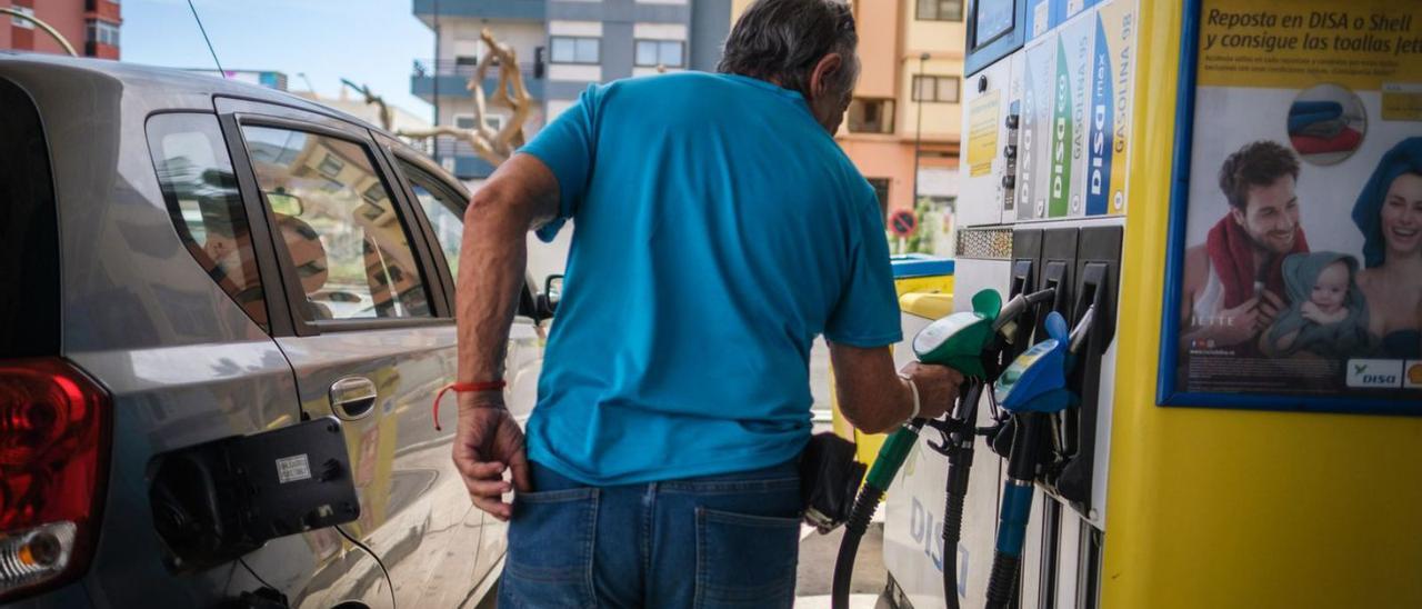 Un conductor junto a su vehículo en una estación de servicio del Archipiélago. | | ANDRÉS GUTIÉRREZ