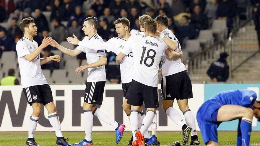 Thomas Müller es felicitado tras anotar el segundo de los seis goles alemanes a Azerbayán. // Efe