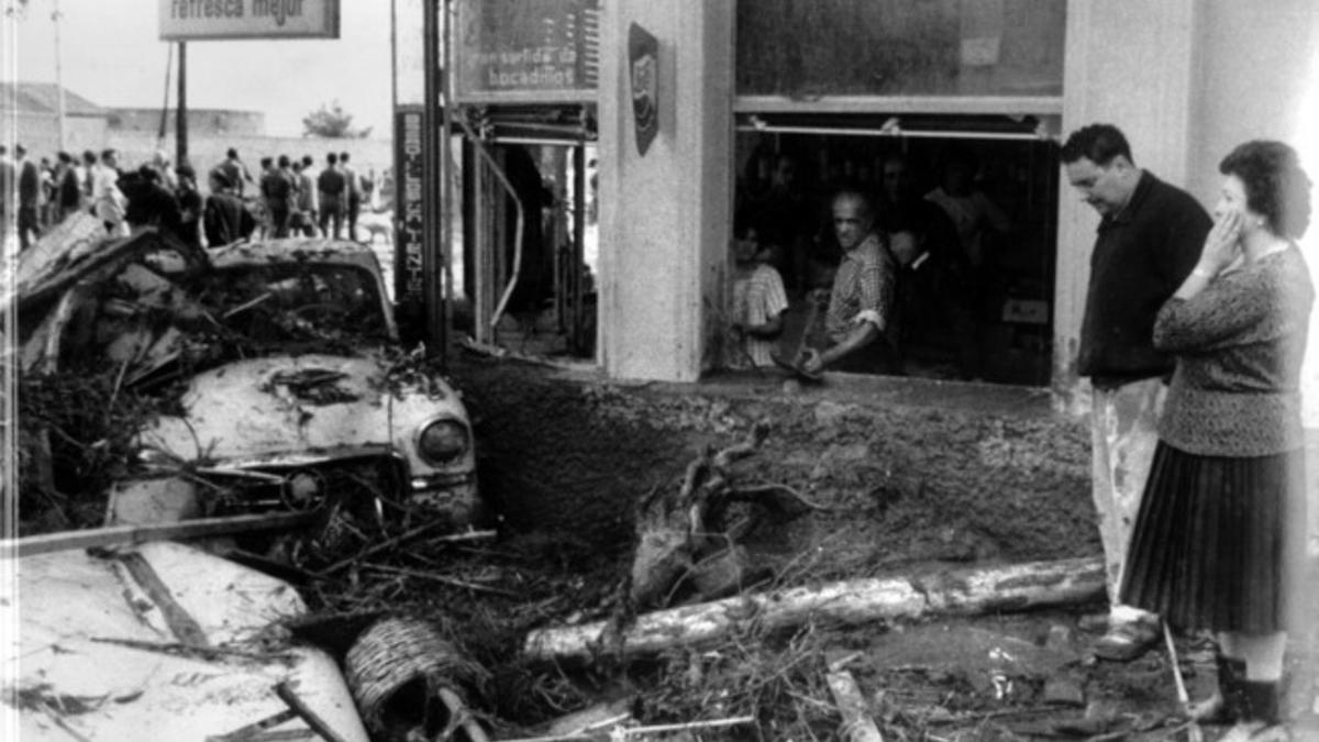 Los vecinos observan el estado de las calles cubiertas por los restos de coches y árboles arrastrados por el agua tras la riada