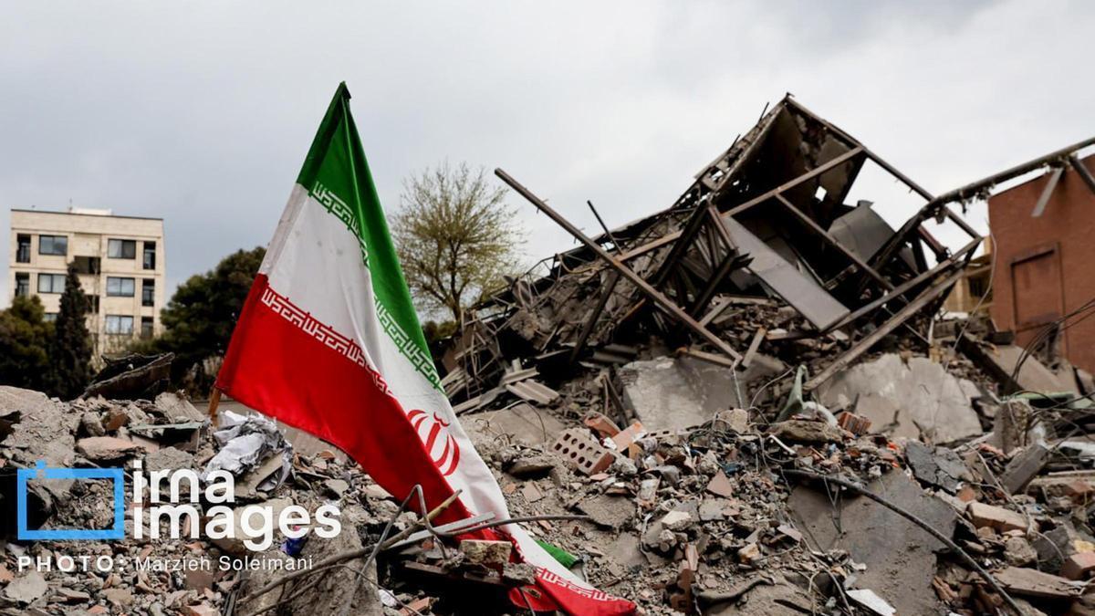 Bandera de Irán sobre los escombros de un edificio en Teherán tras un ataque israelí