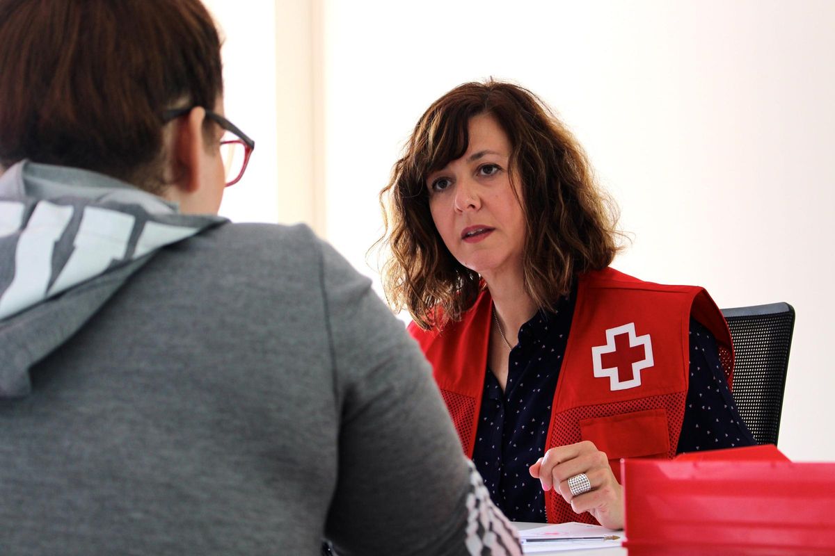 Imagen de una voluntaria de Cruz Roja atendiendo a una persona.