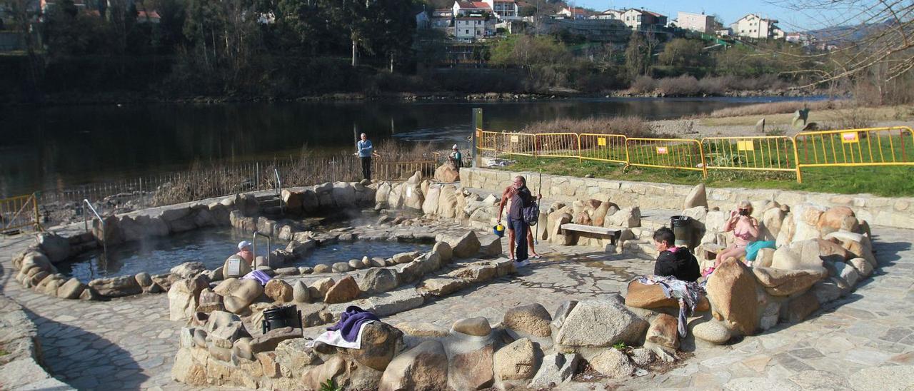 Bañistas, ayer, en las termas de A Chavasqueira, que están fuera de uso.  | // IÑAKI OSORIO