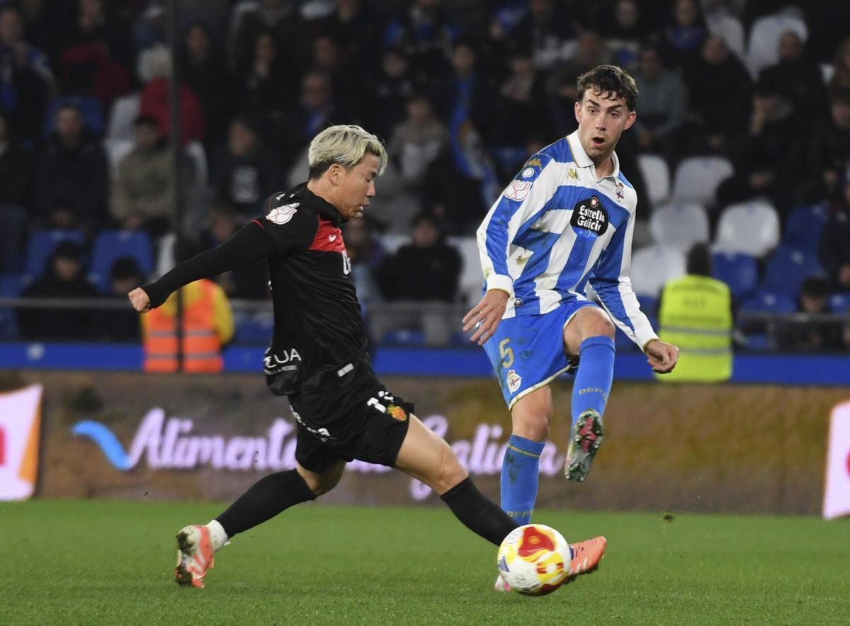 Dani Barcia intenta un pase ante la oposición de Asano, jugador del Mallorca.
