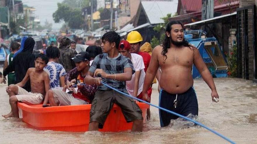 Afectados por las inundaciones se desplazan en barca en la localidad de Bulan.