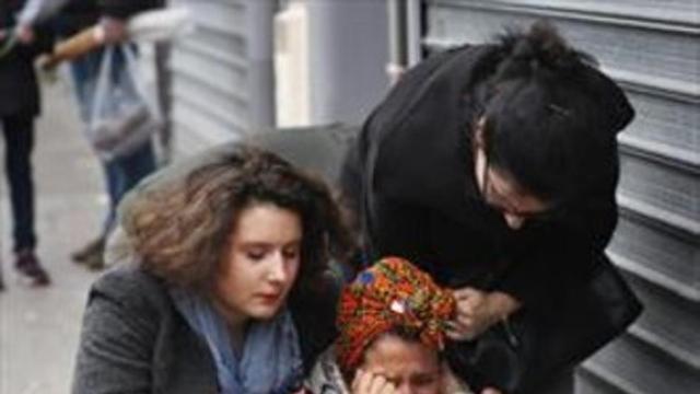 Una mujer es reconfortada cerca de los restaurantes Le Carillon y Le Petit Cambodge, ayer.