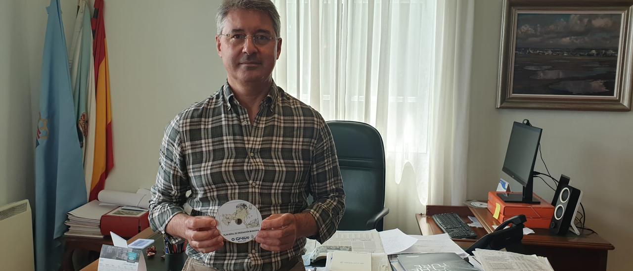 José Cacabelos, en su despacho, con un CD en el que se guarda el PXOM de O Grove.