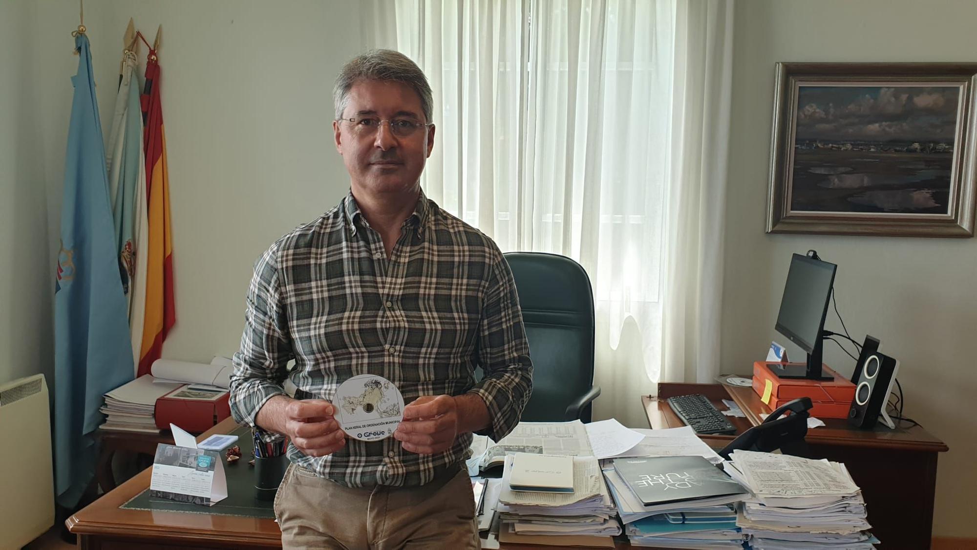 José Cacabelos, en su despacho, con un CD en el que se guarda el PXOM de O Grove.