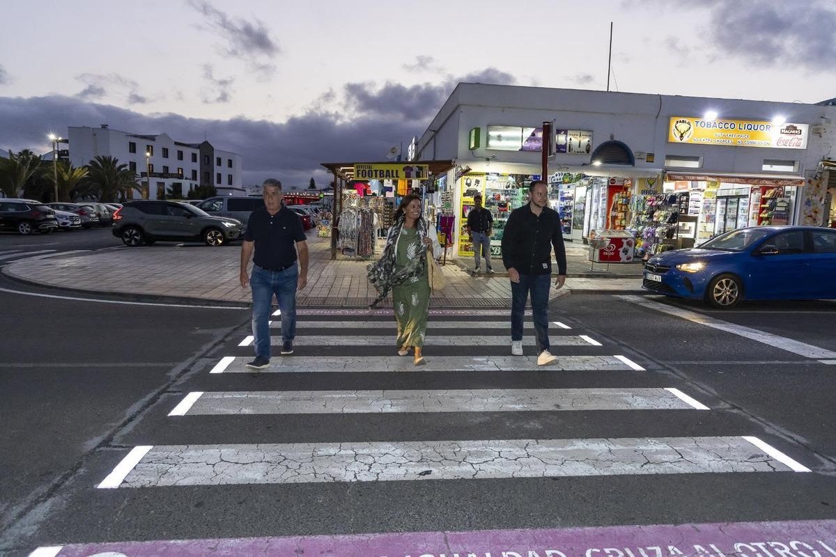 Eugenio Robayna (i), Olivia Duque y Ginés González, en junio de 2025 en el paso de peatones inteligente ubicado frente al Pueblo Marinero, en Costa Teguise