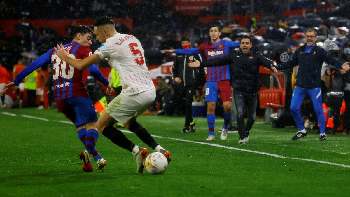 Gavi intenta arrebatar un balón a Ocampos ante la pasión del banquillo azulgrana.