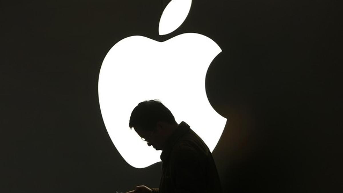 Un hombre mira su iPad en una tienda de Apple en Shanghái, China.