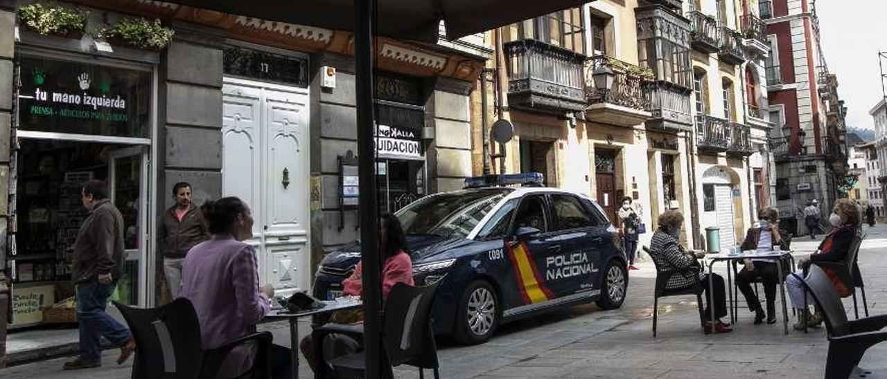 Una patrulla de la Policía Nacional pasa junto a una terraza en el Antiguo, en Oviedo. Miki López