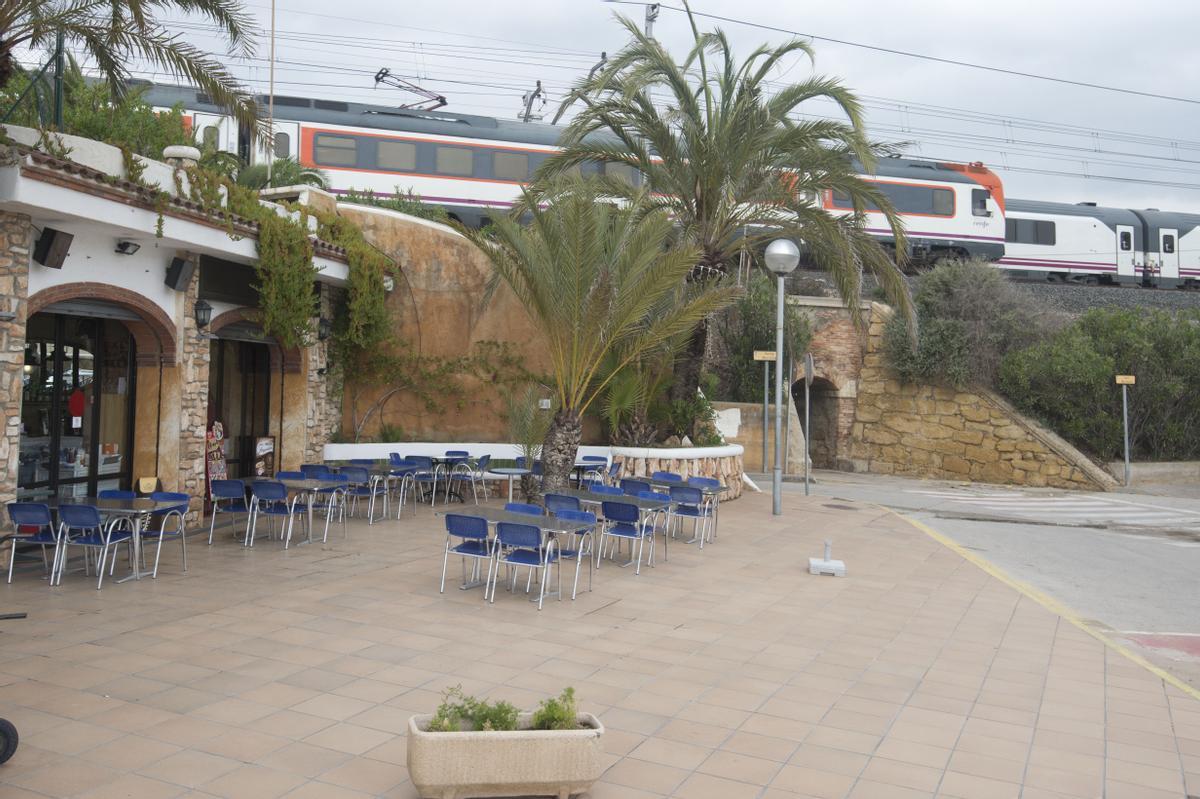 Trenes pasan junto a un bar de la platja Llarga de Roda de Barà, por donde se pretende que pase el Corredor Mediterráneo.