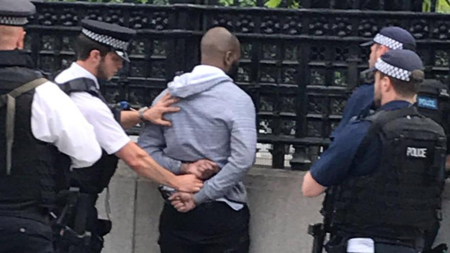Policías junto al detenido fuera del Palacio de Westminster.
