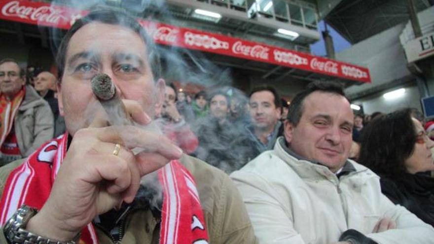 Un espectador fuma un puro en la grada de El Molinón.