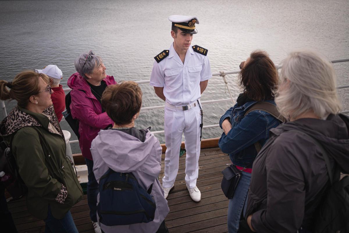 Varias mujeres preguntan a un guardiamarina por la vida a bordo.