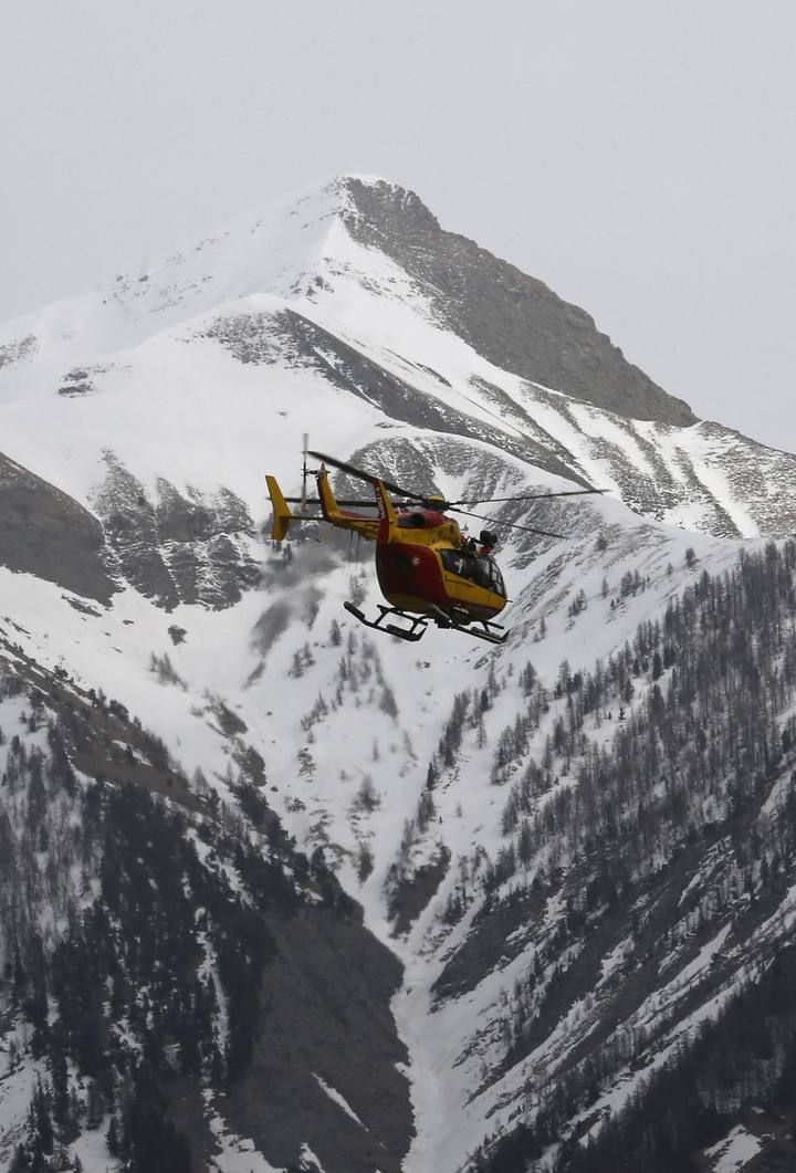 A rescue helicopter from the French Securite Civile flies over the French Alps during a rescue operation near the crash site of an Airbus A320